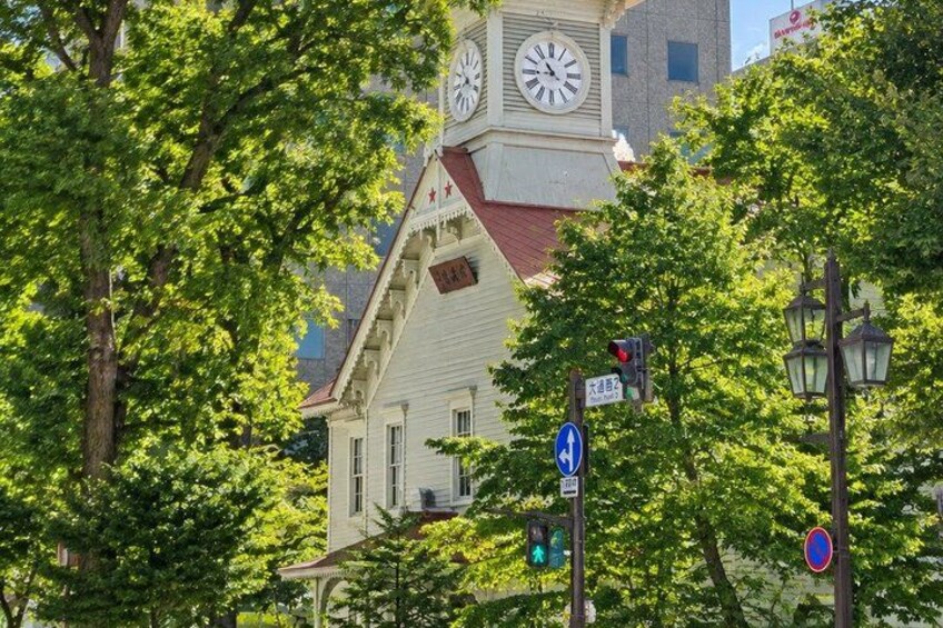 A clock tower, a street sign, and a traffic light. 1