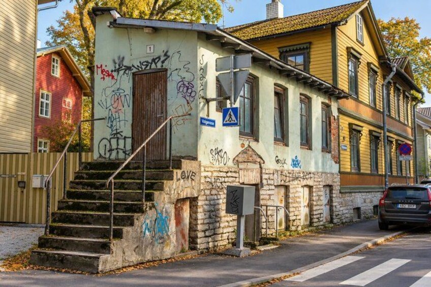 A building with graffiti, a staircase, and a pedestrian crossing sign. 4