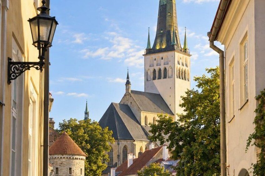 A church with a tall spire and a smaller building with a red roof. 3