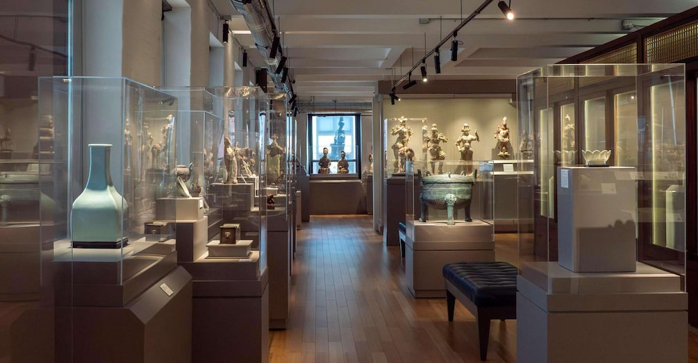 A museum with glass display cases containing sculptures and artifacts. 1