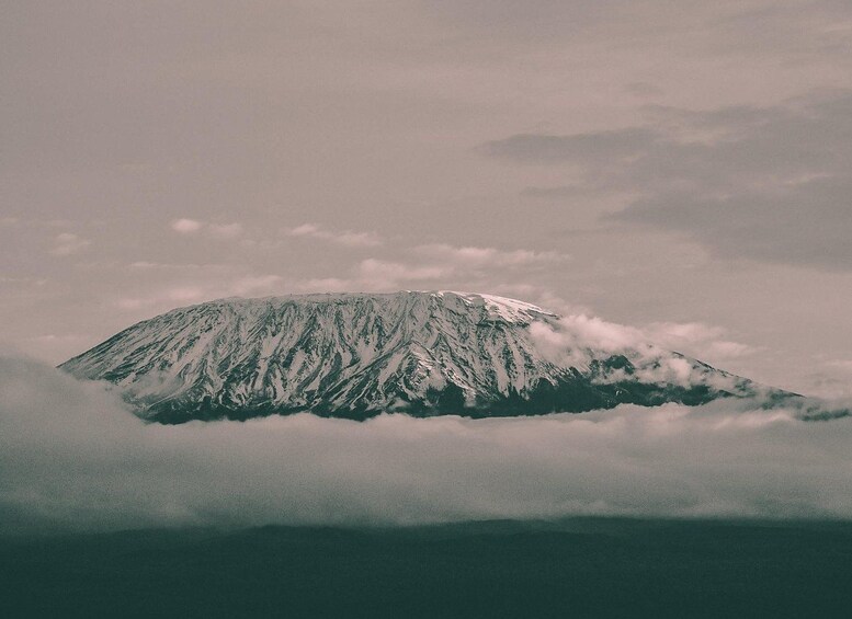 Una montaña nevada parcialmente oculta por nubes. 5