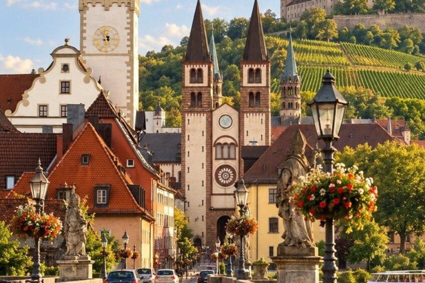 A town square with historic buildings, a clock tower, and a statue. 2