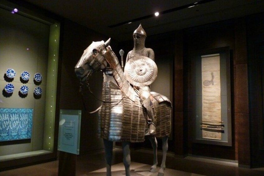A bronze statue of a horse and rider in a museum. 5