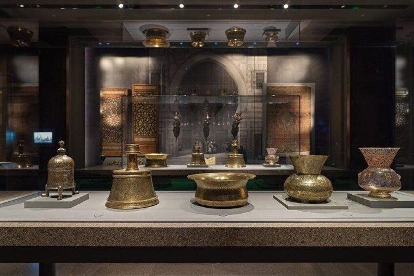 A museum exhibit with ancient golden artifacts, including vases and decorative pieces. 4