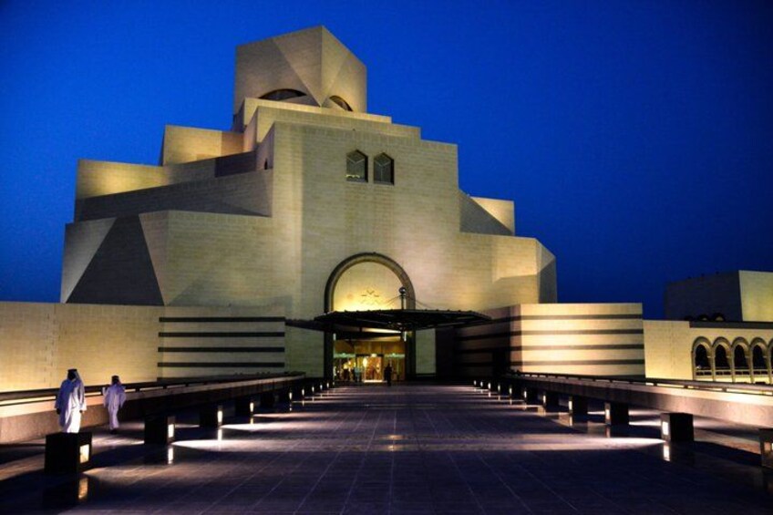 A large, modern building with a unique architectural design, featuring a central arched entrance and multiple levels. 2