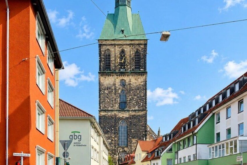 A historic tower with a clock, surrounded by colorful buildings. 5