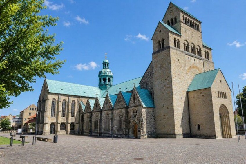 A historic church with a prominent tower and a green-tiled roof. 4