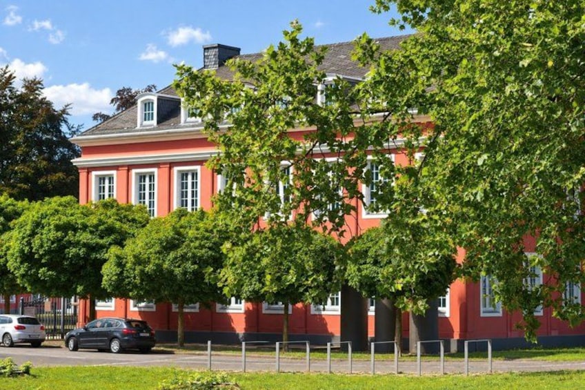 A red building with white trim, surrounded by green trees and a clear blue sky. 4