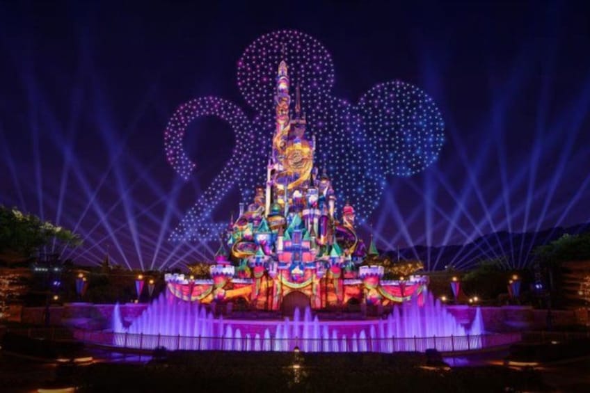 A brightly lit, multi-tiered structure with a central spire, surrounded by a water fountain display. 3