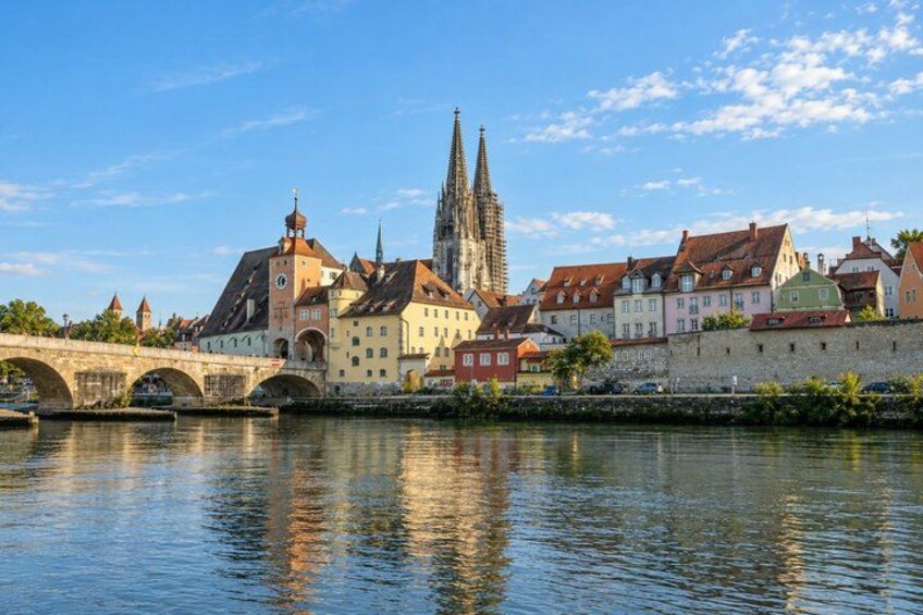 A river with a stone bridge, historic buildings, and a cathedral. 5
