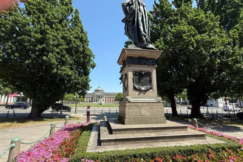 A statue in a park with a building in the background. 3