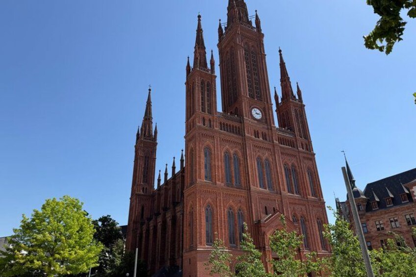 A large red brick church with multiple spires and a clock tower. 5