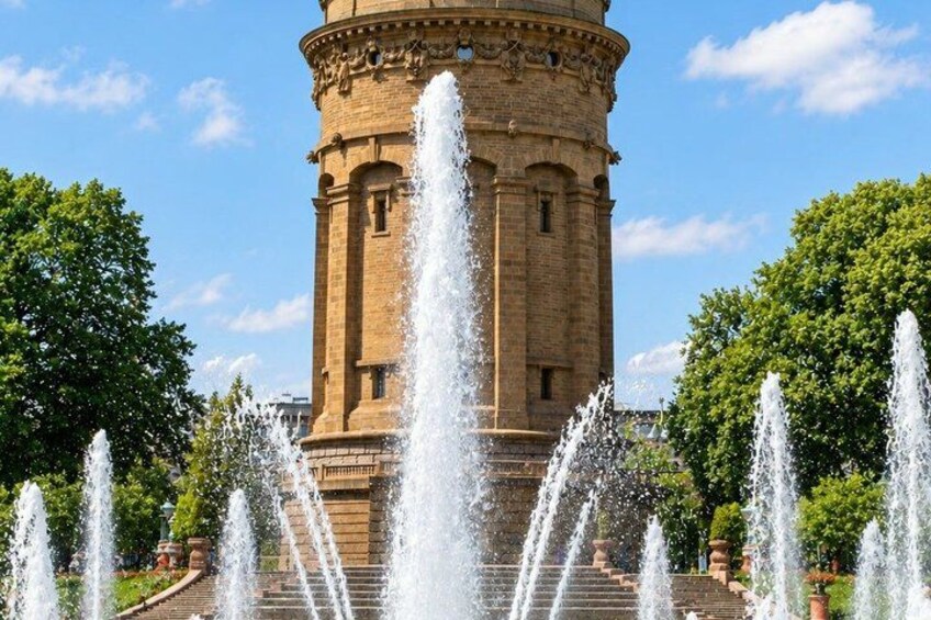 A historic tower with water jets in front. 2