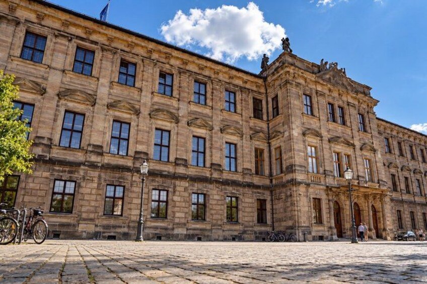 A historic stone building with multiple windows and a central entrance. 3