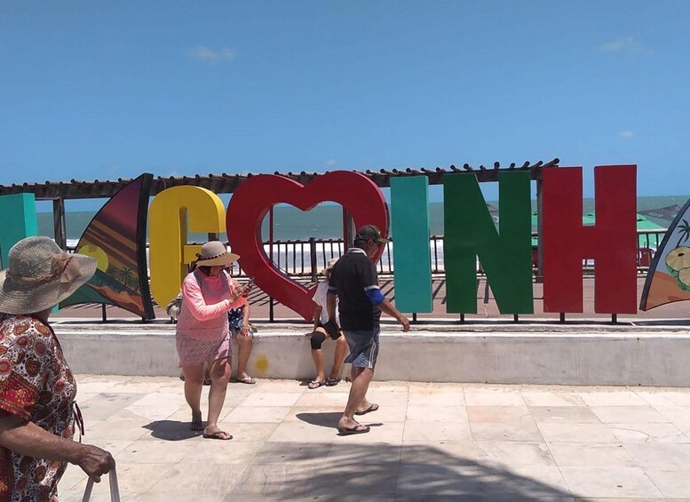 A beachside area with large colorful letters spelling 'COINH' and a heart-shaped structure. 3