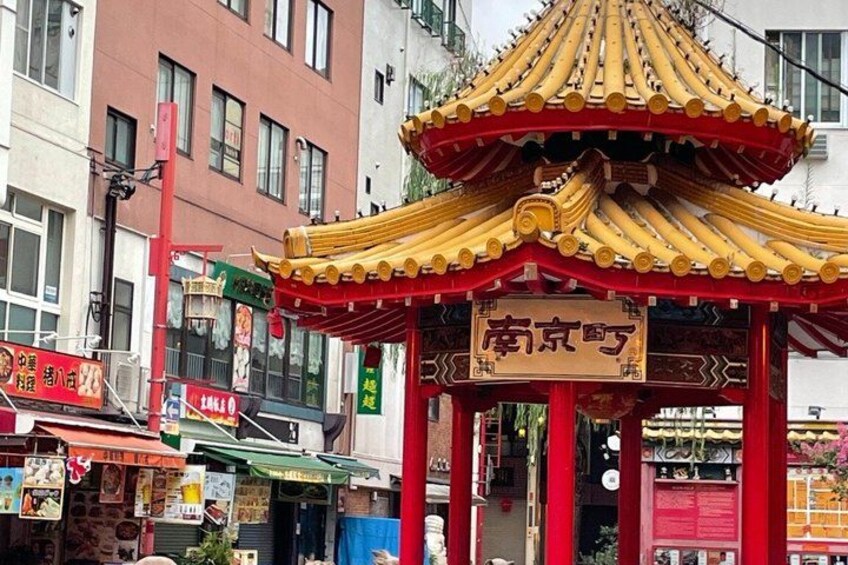 A traditional Chinese pavilion with a signboard, surrounded by urban buildings. 5