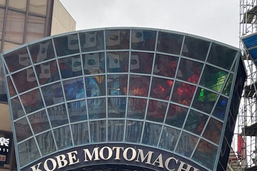 A curved glass facade with the text 'KOBE MOTOMACH' on it. 3