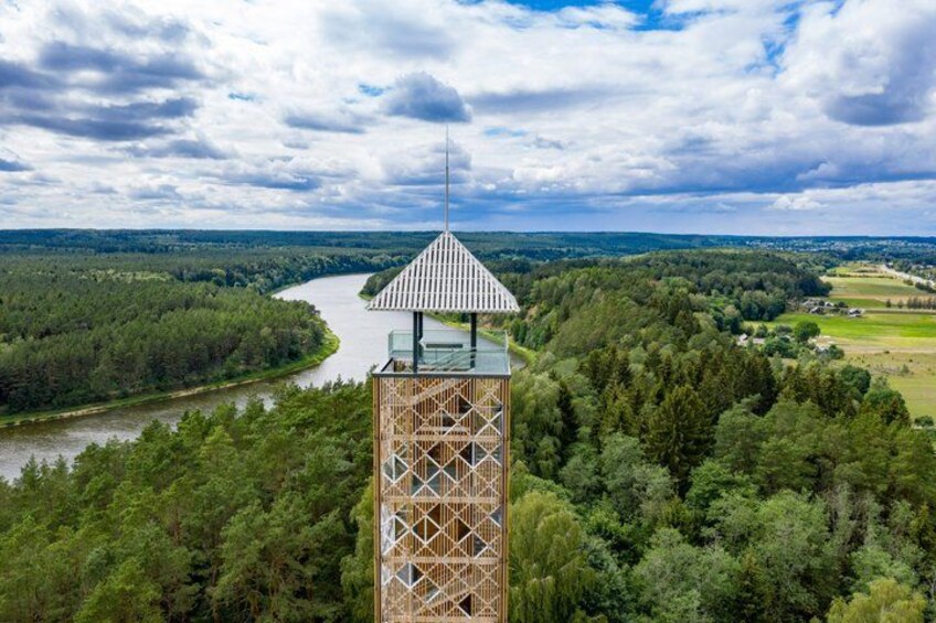 A tower with a triangular roof overlooking a river and forested landscape. 5