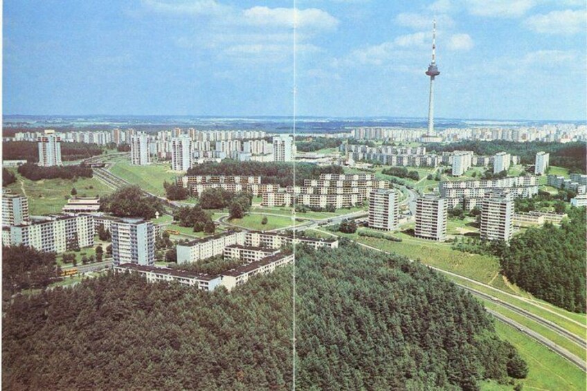 A cityscape with residential buildings, a tower, and a park. 1