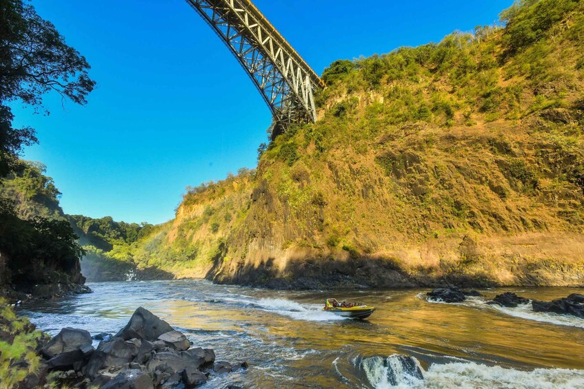 A river with a boat, a bridge, and a forested hillside. 3