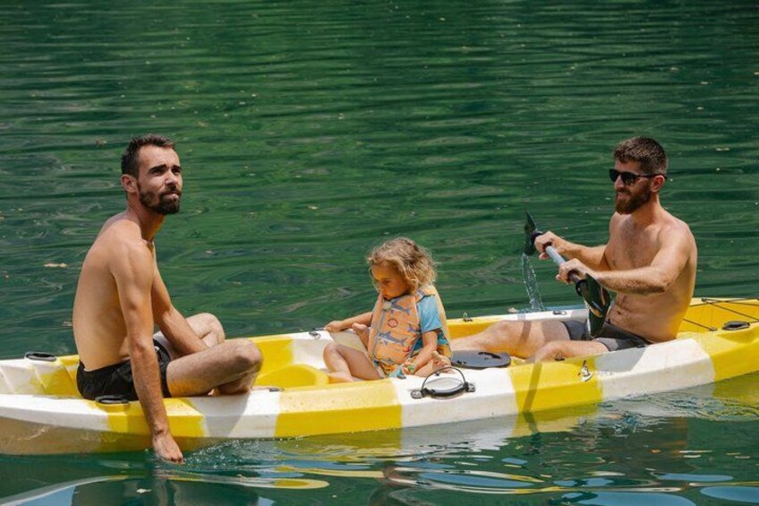 Three people on a yellow and white inflatable boat in a body of water. 4