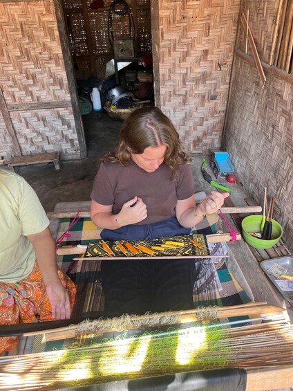 Una persona tejiendo en un telar con hilos de colores. 4