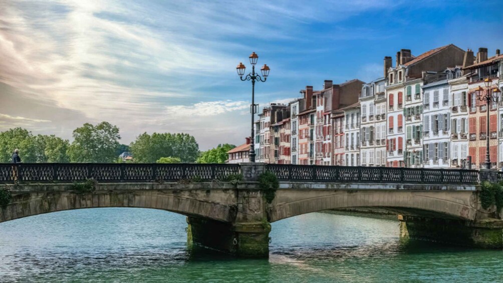 Un ponte di pietra che scavalca un fiume, con edifici sulla riva opposta. 5