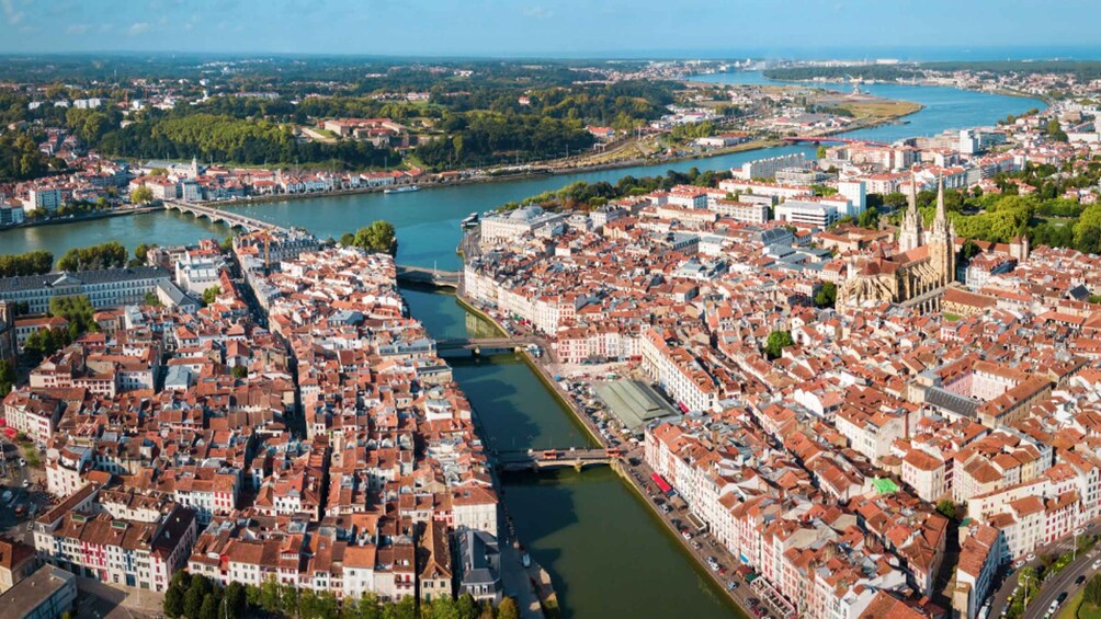 Vista panorámica de una ciudad con un río, edificios históricos y una iglesia destacada. 4