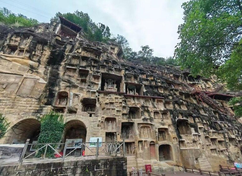 Un templo tallado en roca de gran tamaño, con múltiples niveles de nichos esculpidos y puertas en arco. 3