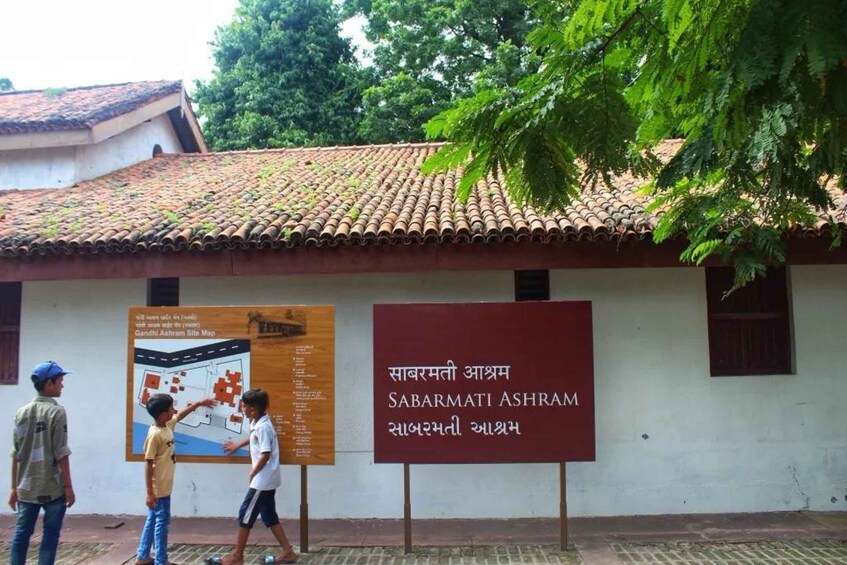 A building with a tiled roof and a signboard in front. 5
