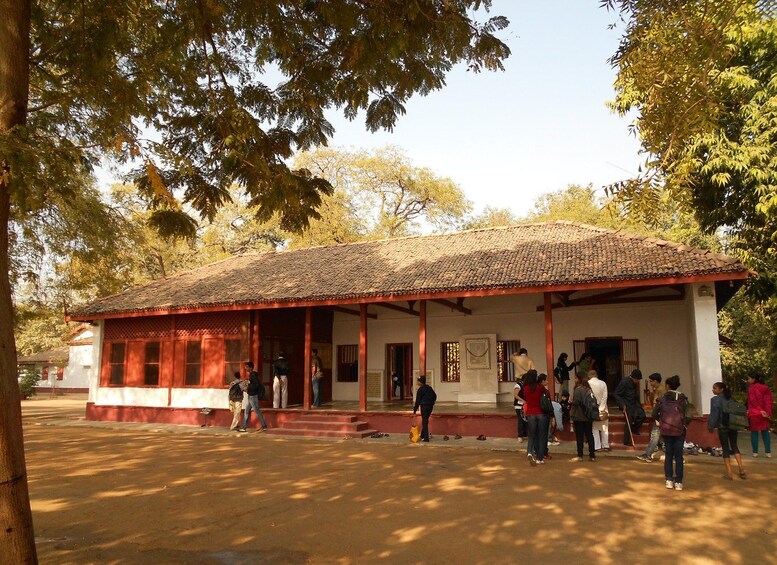 A traditional building with a tiled roof and red columns, surrounded by trees. 3