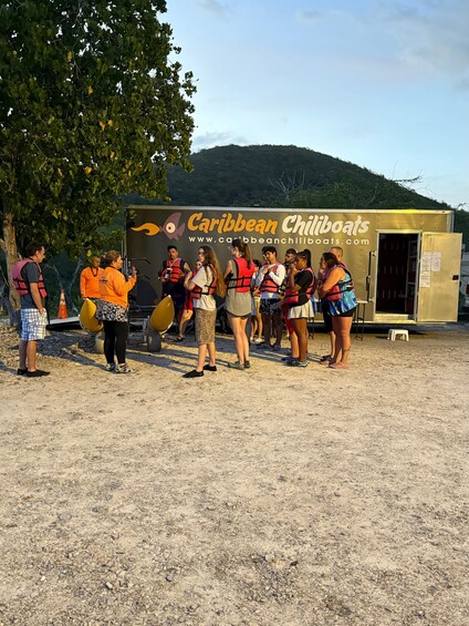 A group of people near a trailer with the text 'Caribbean Chillboats' and a website address. 5