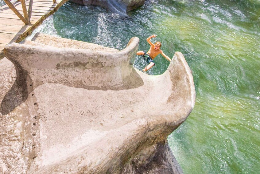 Una persona saltando desde un tobogán de hormigón a una masa de agua. 5