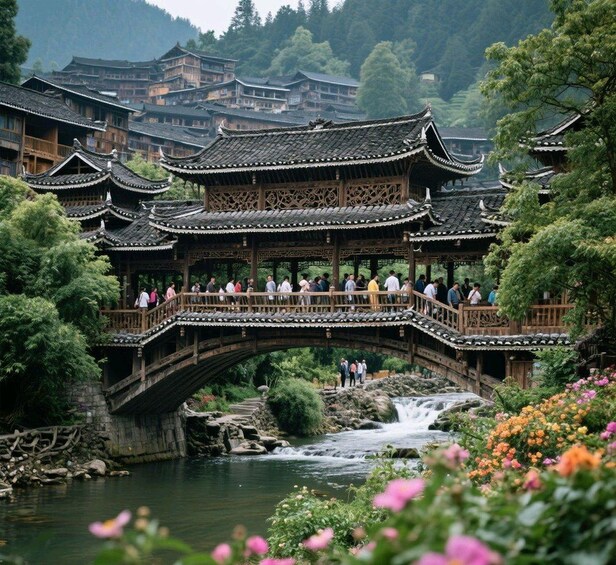 Un puente chino tradicional sobre un río, con turistas, rodeado de vegetación exuberante y edificios históricos. 2