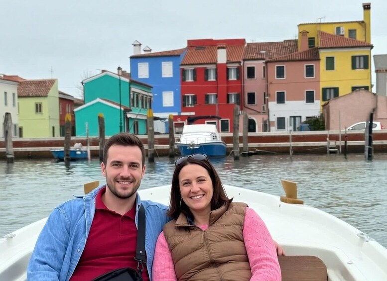 Una pareja en un bote con edificios coloridos al fondo. 3