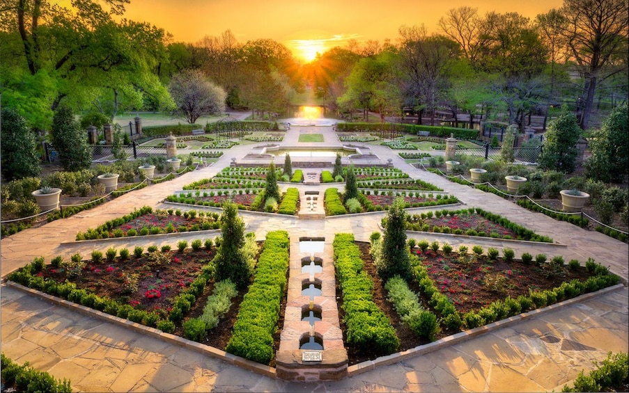 A symmetrical garden with a central water feature, surrounded by neatly trimmed hedges and flowering plants. 5