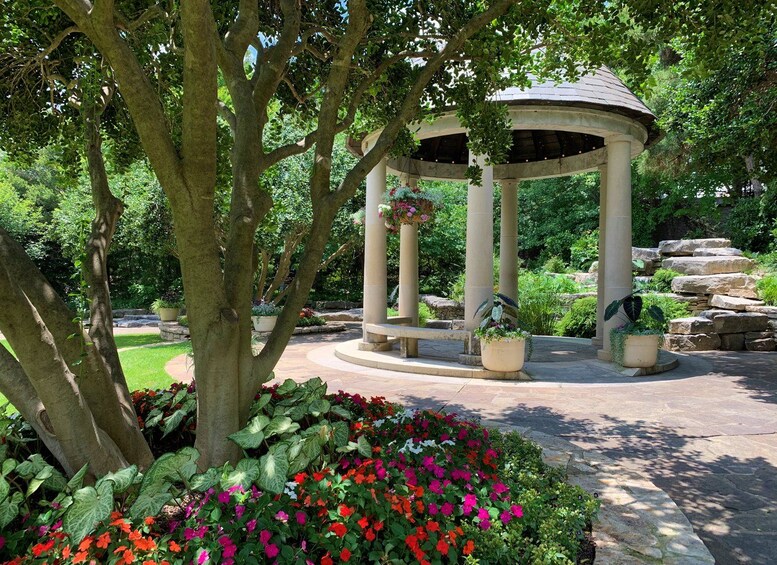 A gazebo surrounded by lush greenery and vibrant flowers. 3