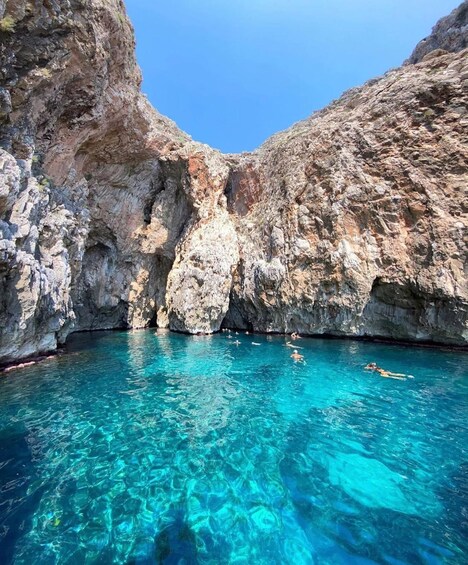 Une piscine d’eau cristalline, entourée de falaises rocheuses. 5