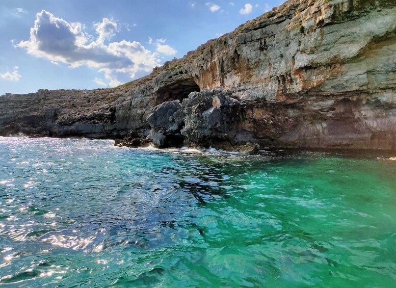 Une falaise côtière surplombant une eau turquoise et limpide, ainsi que des formations rocheuses. 4