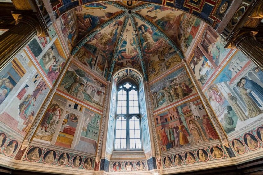 A grand cathedral interior with a central arched window, ornate ceiling frescoes, and detailed wall paintings. 1