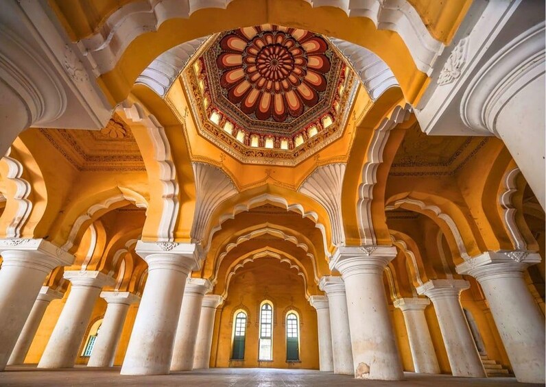 Un interior ornamentado con un amplio diseño circular en el techo, columnas arqueadas y una serie de ventanas. 4