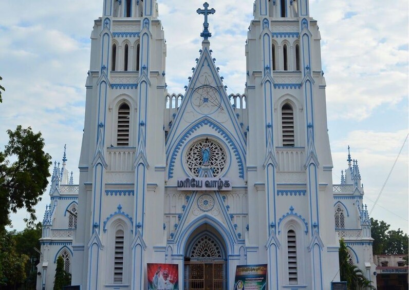 Una iglesia blanca con detalles azules y un amplio ventanal circular. 2