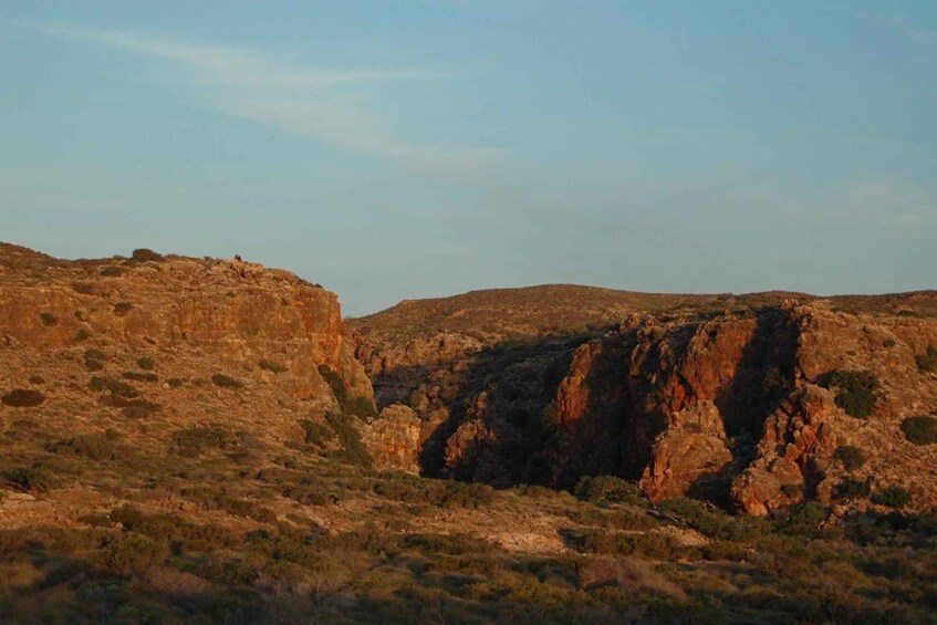 A rugged landscape with rocky hills and sparse vegetation. 1