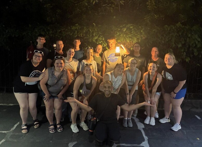 Un grupo de personas posando para una foto en un entorno exterior de noche con iluminación artificial. 5
