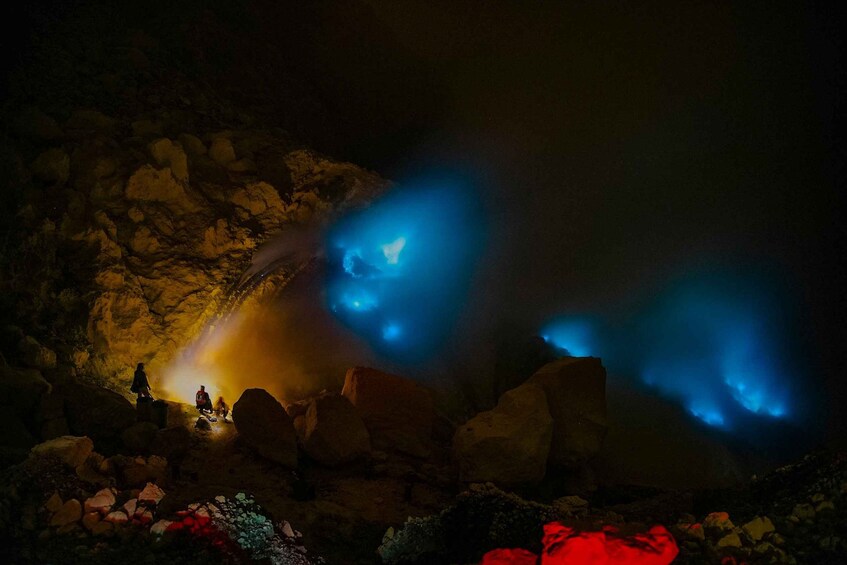 Una cueva con luces azules brillantes y gente explorando. 5