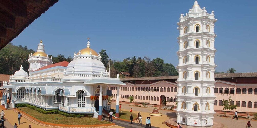A white church with a bell tower, golden domes, and a large open courtyard. 2