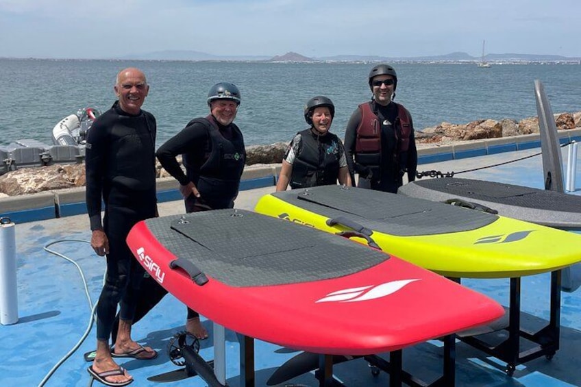 People standing by a boat with surfboards. 4