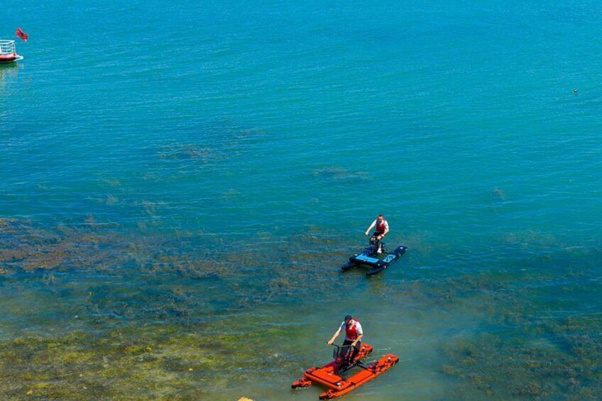 Two people on a blue jet ski in clear blue water. 5