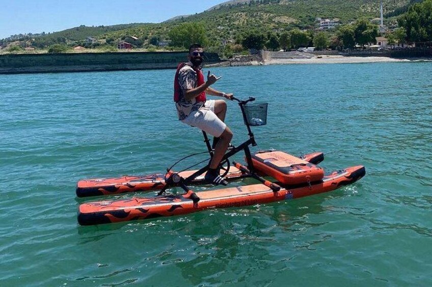 A person riding a water bike on a calm lake with a hilly landscape in the background. 2