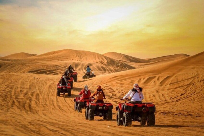 A group of people on quad bikes in a desert landscape with sand dunes. 5